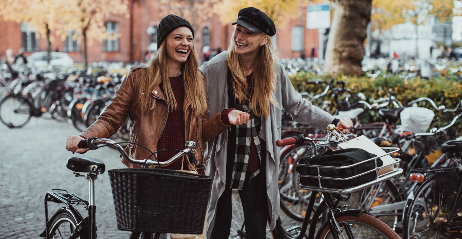 Twee studenten lopend met hun fiets aan de hand