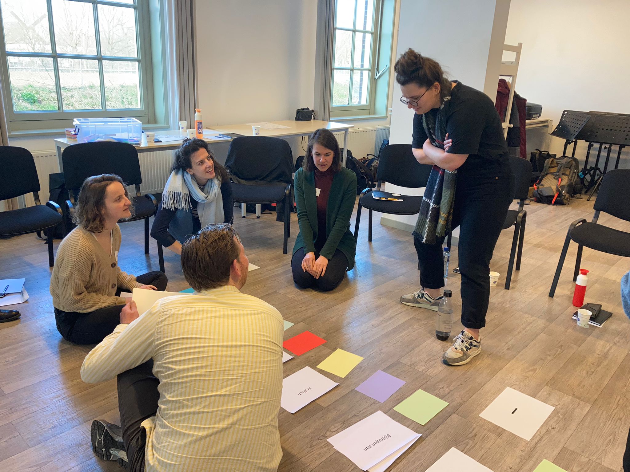 Collega’s zittend op de grond ontdekken met kleurkaarten eigen talenten tijdens Arcadis Imagineers