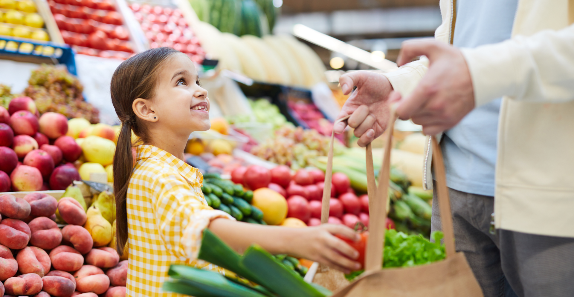 Meisje koopt groenten samen met haar vader op de markt. Arcadis ziet voedselindustrie als spil in klimaatverandering