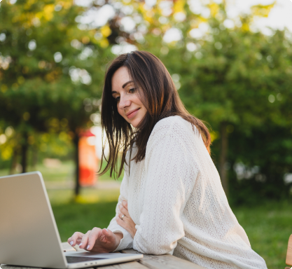  woman engrossed in her work, sitting with a laptop at a table.