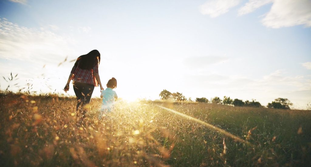 Mother and child walking in a field