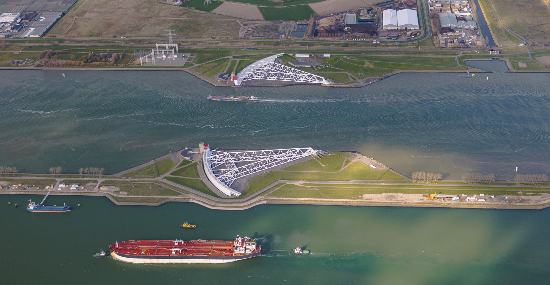 Ocean bordered by lush greenery and storm surge barriers.