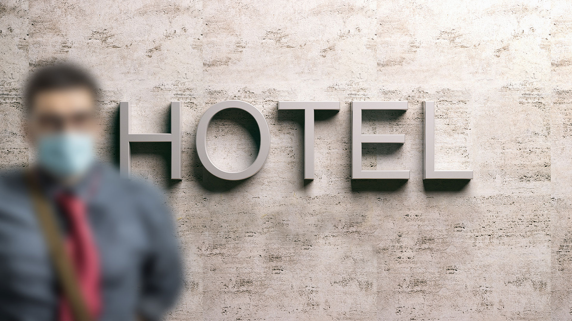 Mann mit medizinischer Mund-Nasen-Bedeckung in Hotel-Lobby