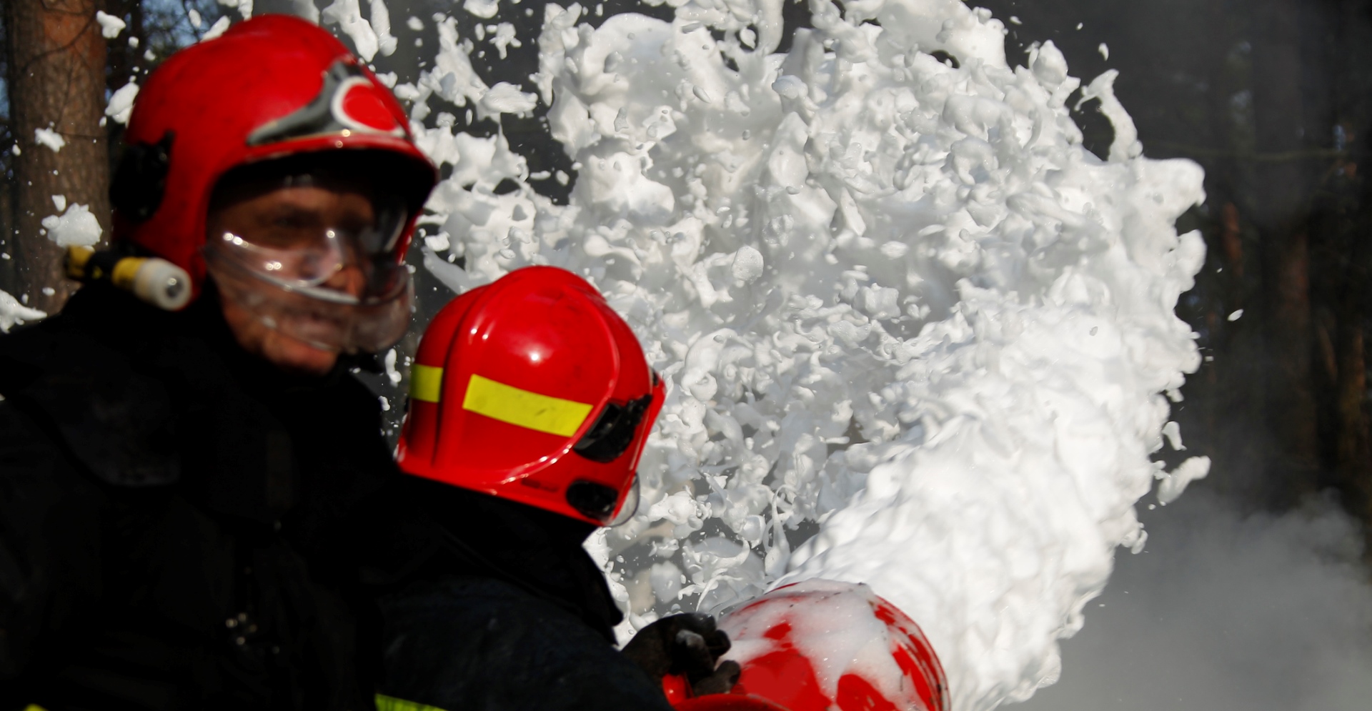 Twee brandweerlieden die een brand proberen te blussen